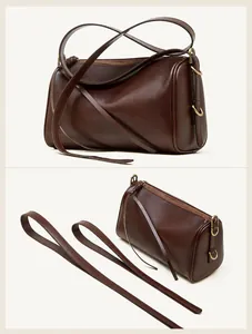 Vue détaillée à 45 degrés du sac tonneau en cuir marron foncé avec boucles dorées