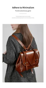 Detail of a brown oil-wax leather backpack showing minimalist flap and metallic buckles