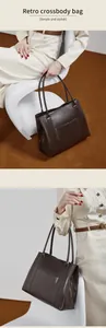 Detailweergave van de donkerbruine lederen tas met textuur, ritsen en handvatten