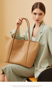 Detail of minimalist camel leather tote bag showing smooth texture and large front pocket