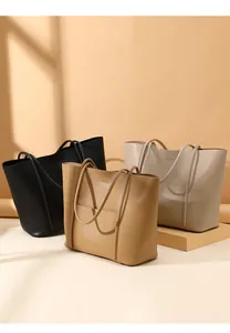 Detailed view of three premium leather tote bags in black, camel, and light grey colors