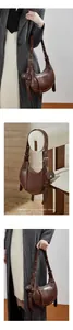 Detail of dark brown croc-pattern leather hobo bag with a matching mini coin purse