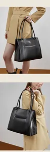 Detail van een zwarte lederen tote bag met getextureerde afwerking en metalen rits