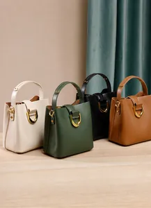 Détail de quatre sacs seau en cuir montrant la texture premium et la boucle en D métallique