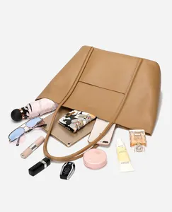 Brown leather tote bag interior showing capacity for tablet, umbrella, and accessories