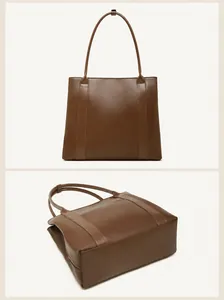 Detailopname van de achterkant en de versterkte bodem van de bruine leren tote tas