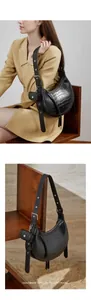 Detail of black croc-embossed crescent underarm bag with adjustable strap and mini pouch