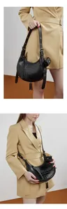 Detail of black croc-embossed crescent bag with adjustable strap and mini pouch