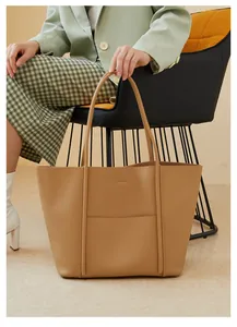 Close-up of a khaki leather tote bag featuring a front pocket for office commuting
