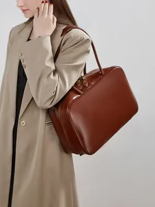 Classic caramel brown leather bowling handbag with minimalist design and dual zipper