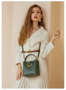 Détail d'un sac seau vert foncé avec boucle en U dorée vintage et cuir de haute qualité
