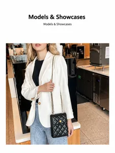 Details einer schwarzen gesteppten Mini-Umhängetasche mit goldener Blumenschließe