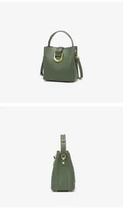 Vue détaillée du sac seau vert foncé avec boucle dorée et bandoulière réglable pratique