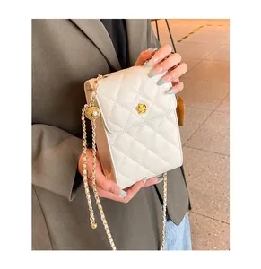 Detail der cremeweißen gesteppten Leder-Handytasche mit goldener Schließe und Kette