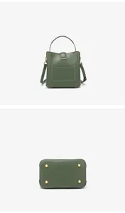 Détail du sac seau vert foncé montrant les coutures blanches et les pieds de protection