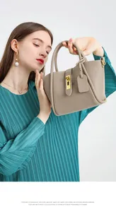 Detail of grey pebble leather bucket bag with gold buckle hardware and matching tag