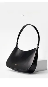 Detail view of the gold logo and matte black leather texture on this chic hobo underarm bag