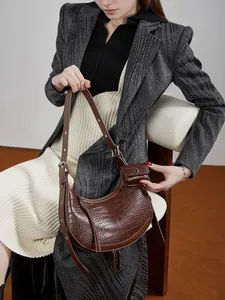 Brown crocodile embossed crescent hobo bag with mini coin purse and tassel details