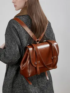 Vintage brown leather backpack for women featuring a flap closure and buckle straps