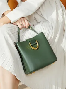 Sac seau en cuir vert foncé avec boucle fer à cheval dorée et poignée pour femme