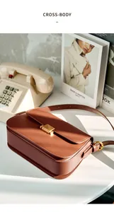 Detail of vintage brown leather box bag with gold metal clasp and smooth finish