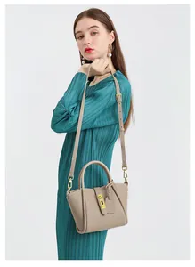 Taupe leather bucket bag with litchi grain detail and elegant gold twist lock hardware