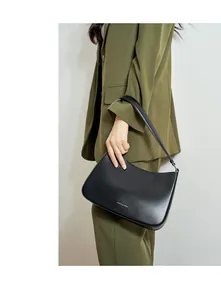 Detail of minimalist black leather hobo bag with Fashion & Trend metallic text