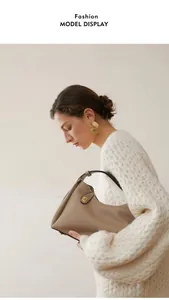 Gros plan sur la texture du cuir et la boucle dorée d'un sac bandoulière camel