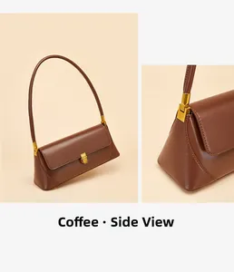 Detail view of coffee leather baguette bag with golden metal push-lock and side stitching