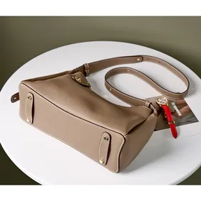 Détail du sac en cuir à grain lychee avec pieds de protection dorés sur la base