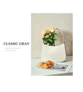 Detail of classic gray leather bag with gold lettering and decorative yellow roses