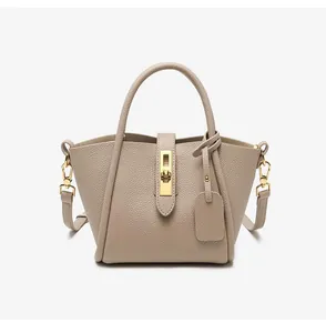 Close-up of beige pebbled leather bucket bag with gold lock and textured finish