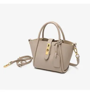 Macro detail of lychee grain leather texture and golden twist lock on bucket bag