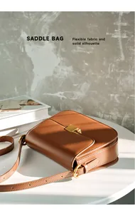 Detailed view of caramel leather saddle bag with gold buckle under aesthetic sunlight