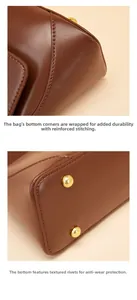 Macro detail of brown leather bag with reinforced stitching and gold protective base studs