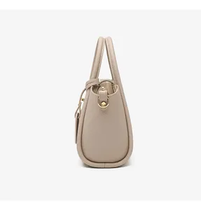 Detail view of apricot bucket bag featuring pebbled leather texture and metal D-rings