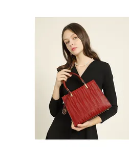 Fashionable red leather handbag featuring unique wavy embossed texture and golden hardware