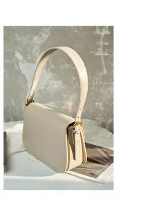 Detailed side view of an ivory leather bag featuring elegant accordion gusset design