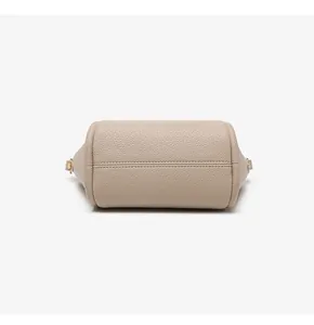 Close-up of beige lychee grain leather bucket bag base with detailed stitching