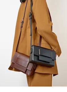 Detailed view of the woven leather crossbody bag with wide strap on a model shoulder