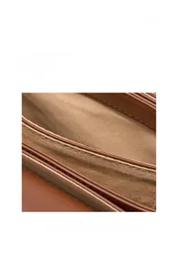 Detail view of premium dark brown leather bag showing precision stitching and fabric lining