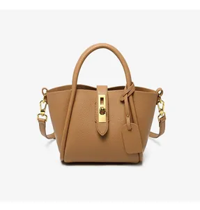 Close-up of caramel leather bucket bag with lychee texture and gold metal hardware