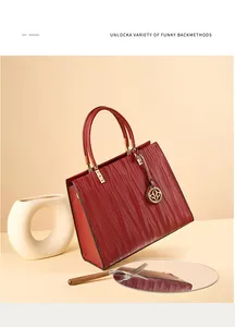 Close-up of wine red leather handbag featuring textured ripple pattern and gold hardware
