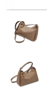 Détail de la texture en cuir grainé et du fermoir tournant en métal sur le sac gris foncé