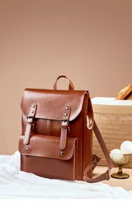 Classic brown leather backpack with retro metal buckles and elegant flap cover detail