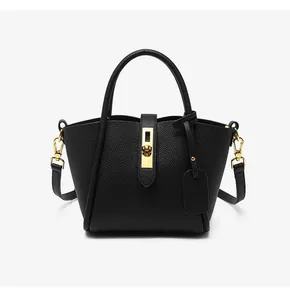 Close-up of black lychee leather bucket bag with premium gold rotating metal lock