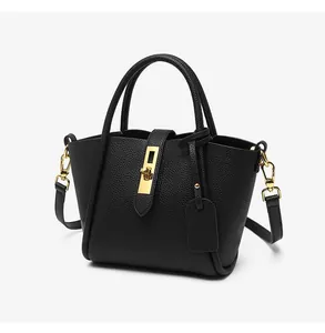 Detailed close-up of black lychee grain leather handbag with gold twist-lock hardware