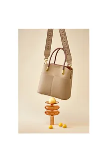 Dettaglio borsa a secchiello in vera pelle con tracolla jacquard e grana litchi