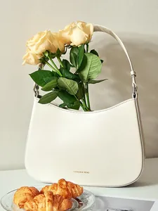 Chic cream leather baguette bag with 'FASHION & TREND' text and elegant half-moon design