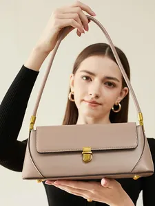 Minimalist light brown leather baguette bag with a premium gold metallic clasp closure